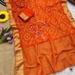 A flat lay of four colorful sarees featuring gold Gota Patti work and Nazbin Jacquard borders arranged on a white fur rug.