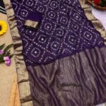 A flat lay of four colorful sarees featuring gold Gota Patti work and Nazbin Jacquard borders arranged on a white fur rug.