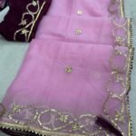 A beautiful deep purple Organza saree with detailed gold Gota patti handwork and a contrasting bright blue blouse piece.