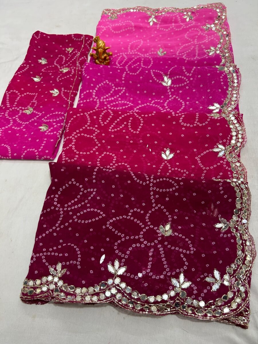 A vibrant Bandhani saree in shades of pink and maroon with intricate mirror work border and handwork motifs.