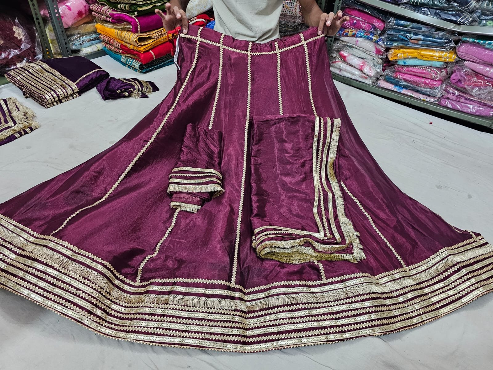 Red Jaipuri Gota Patti Lehenga Choli in Chinon Silk 8 A beautiful woman posing in a vibrant red Jaipuri lehenga choli with detailed Gota Patti work.