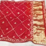 A vibrant pink and orange Jaipuri silk saree with gold gota patti diamond patterns and a rich golden border.