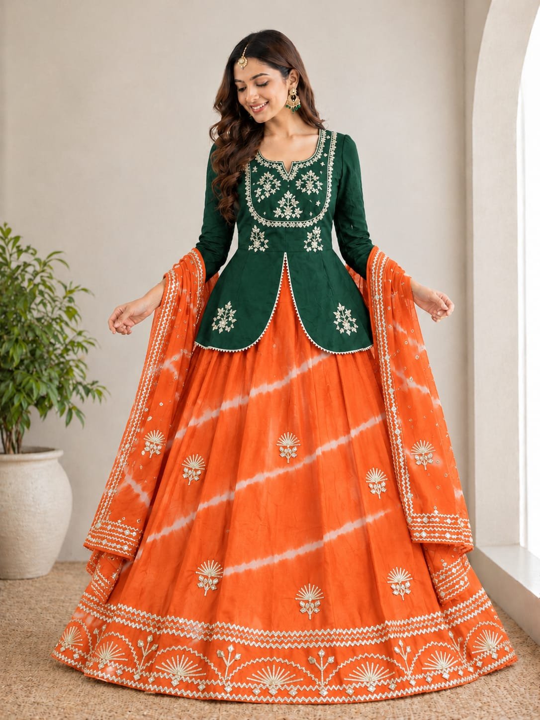 Jaipuri Lehenga with Gota Patti Work in Chinon Silk 4 A woman posing in a blue and sky blue tie-dye pattern Chinon silk lehenga set with intricate Gota Patti handwork on a peplum blouse.