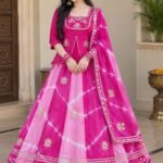 A woman posing in a blue and sky blue tie-dye pattern Chinon silk lehenga set with intricate Gota Patti handwork on a peplum blouse.