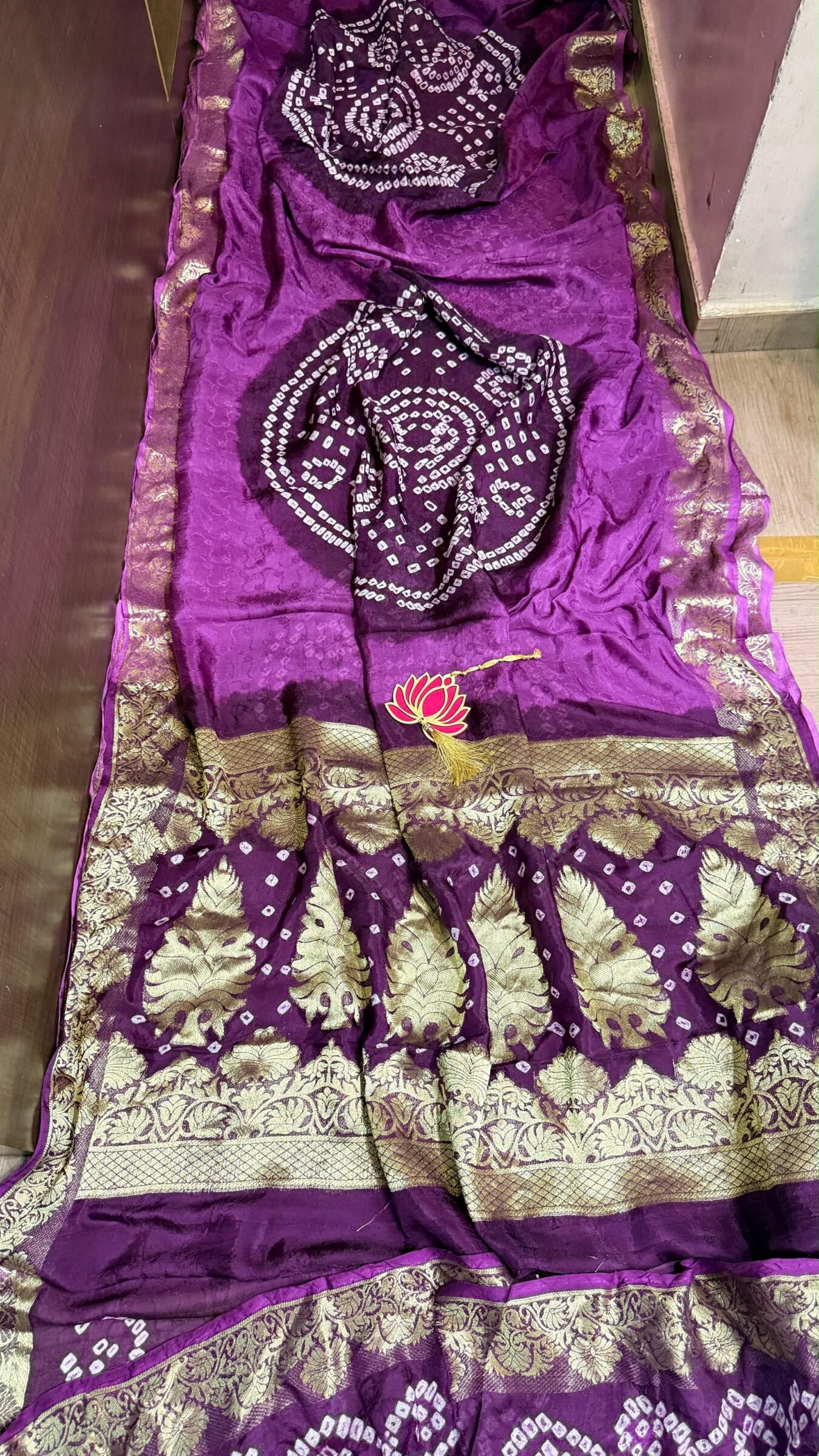 Pure Jamnagari Silk Bandhej Saree with Zari Border 9 A vibrant orange Pure Jamnagari Silk Bandhej saree with intricate golden zari border and a hand-woven zari pallu.