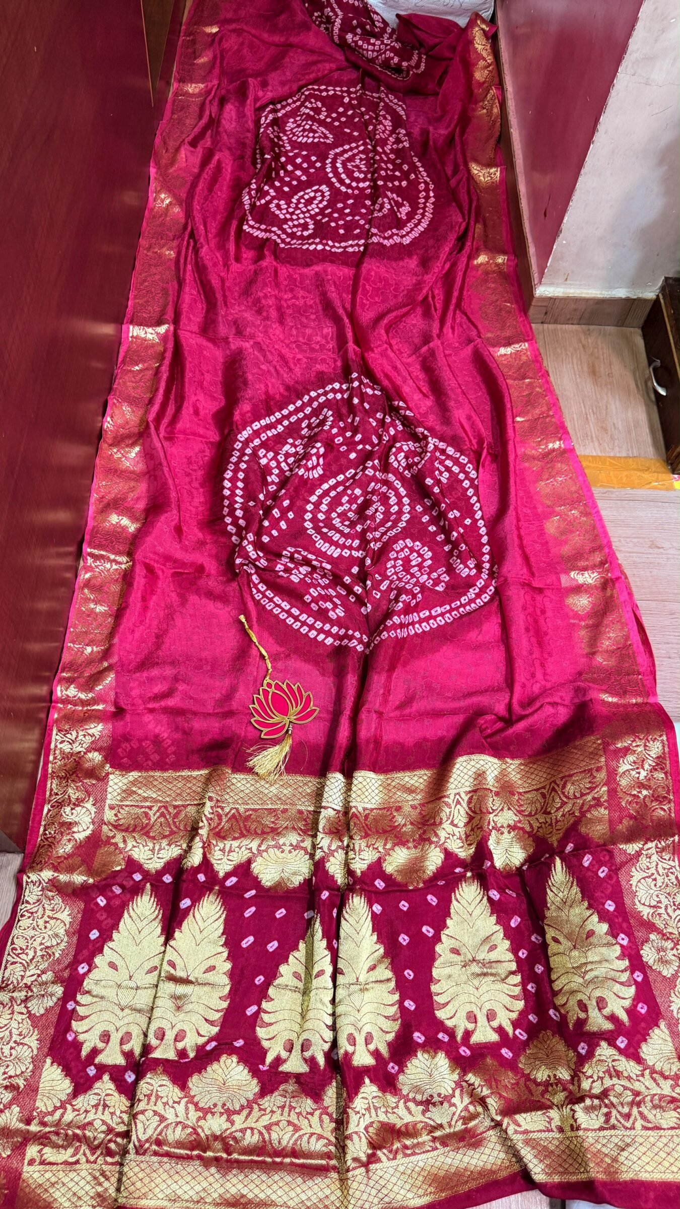 Pure Jamnagari Silk Bandhej Saree with Zari Border 3 A vibrant orange Pure Jamnagari Silk Bandhej saree with intricate golden zari border and a hand-woven zari pallu.