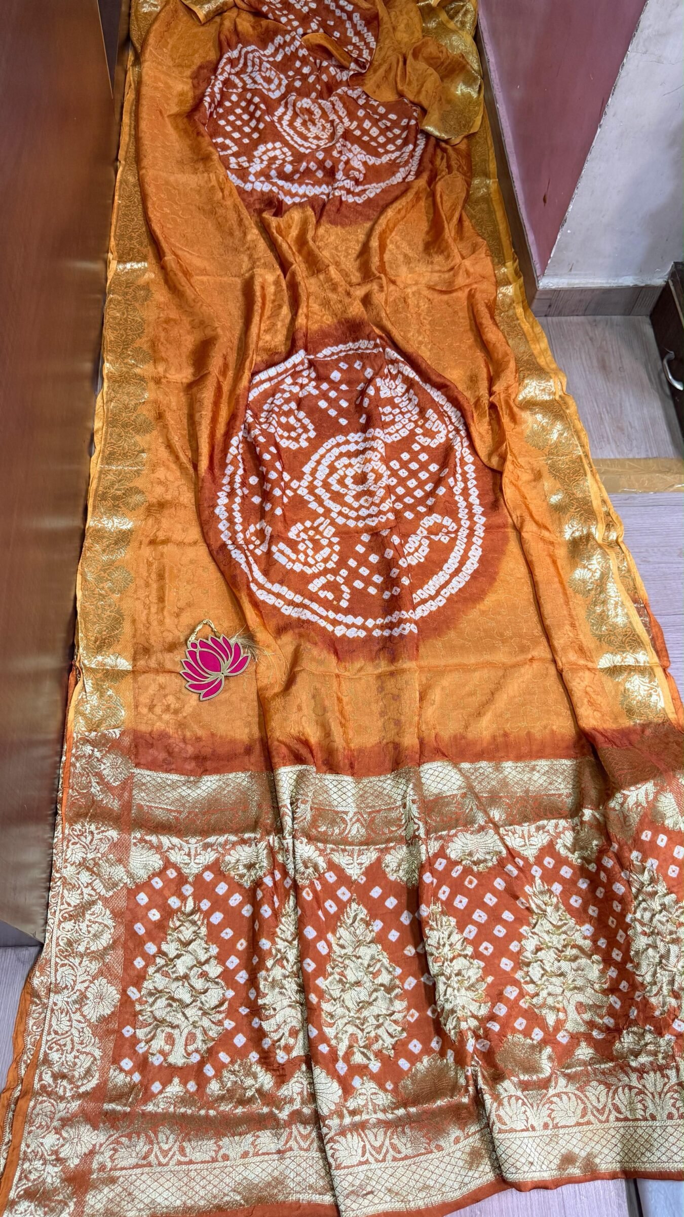 Pure Jamnagari Silk Bandhej Saree with Zari Border 8 A vibrant orange Pure Jamnagari Silk Bandhej saree with intricate golden zari border and a hand-woven zari pallu.