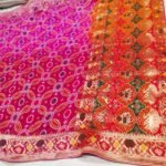A close-up of a pink and orange Pure Khadi Jhorjhat Banarashi Bandhej saree with heavy zari and meena work.