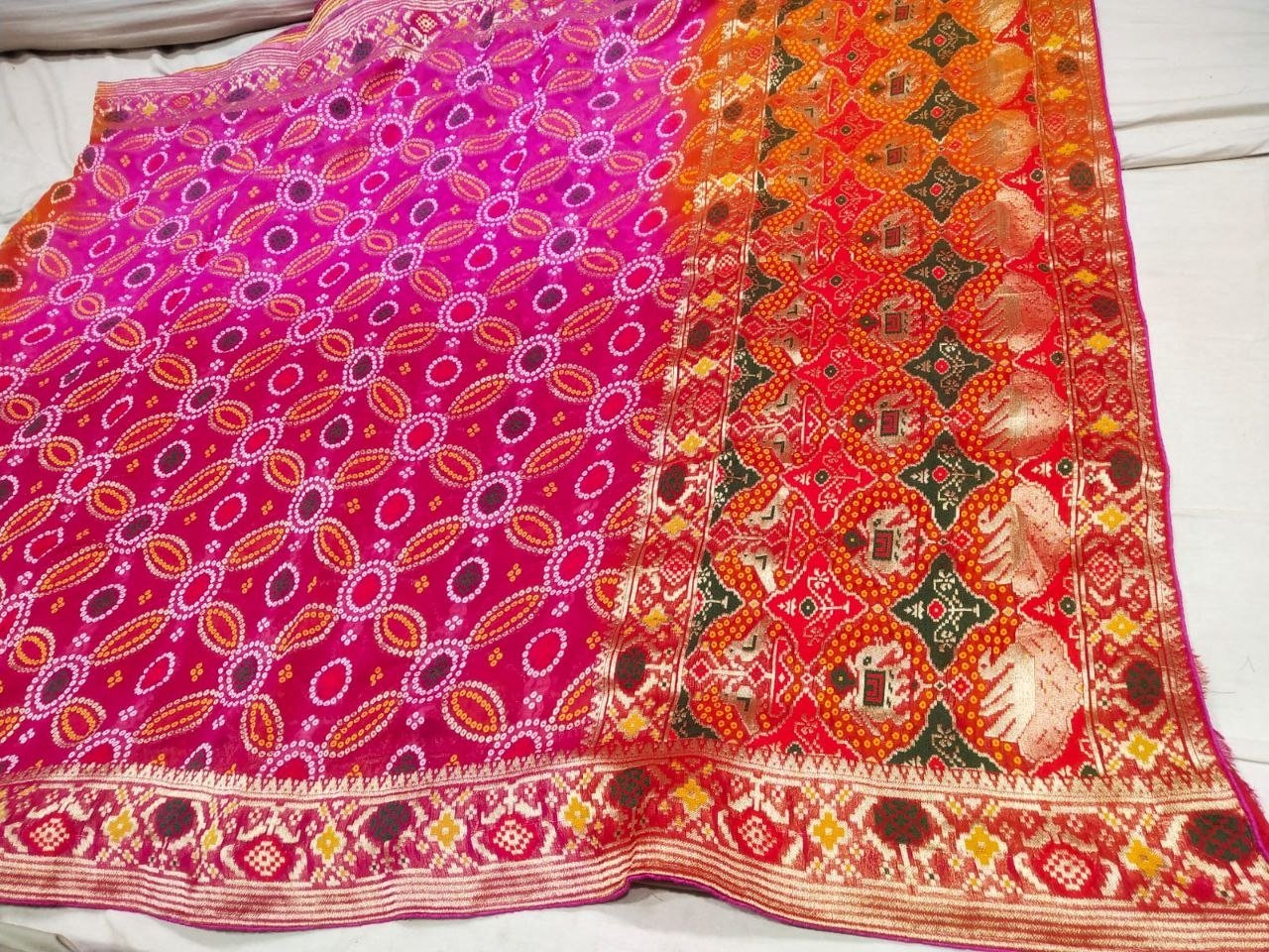 Pure Khadi Jhorjhat Banarashi Bandhej Saree 1 A close-up of a pink and orange Pure Khadi Jhorjhat Banarashi Bandhej saree with heavy zari and meena work.