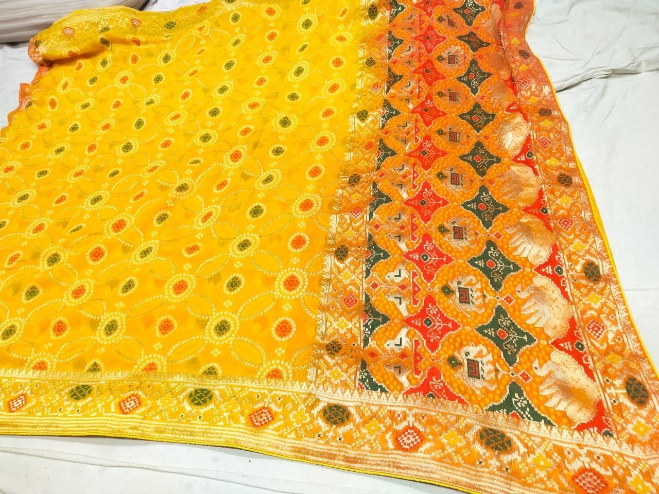 Pure Khadi Jhorjhat Banarashi Bandhej Saree 2 A close-up of a pink and orange Pure Khadi Jhorjhat Banarashi Bandhej saree with heavy zari and meena work.