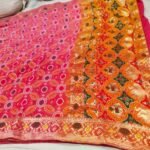 A close-up of a pink and orange Pure Khadi Jhorjhat Banarashi Bandhej saree with heavy zari and meena work.