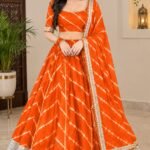 A woman wearing a bright orange Chinon Leheriya lehenga with gota patti work and a matching plain blouse.