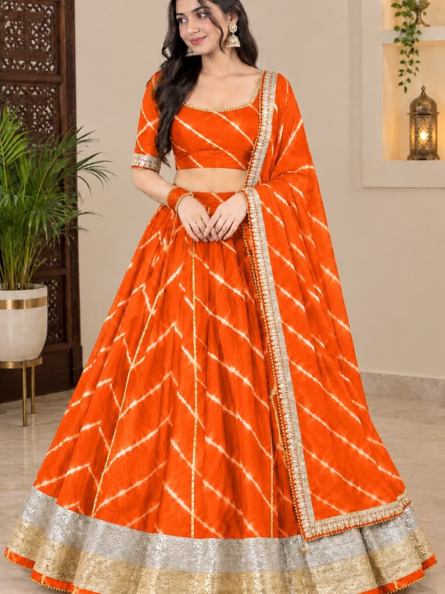 A woman wearing a bright orange Chinon Leheriya lehenga with gota patti work and a matching plain blouse.