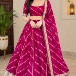 A woman wearing a bright orange Chinon Leheriya lehenga with gota patti work and a matching plain blouse.