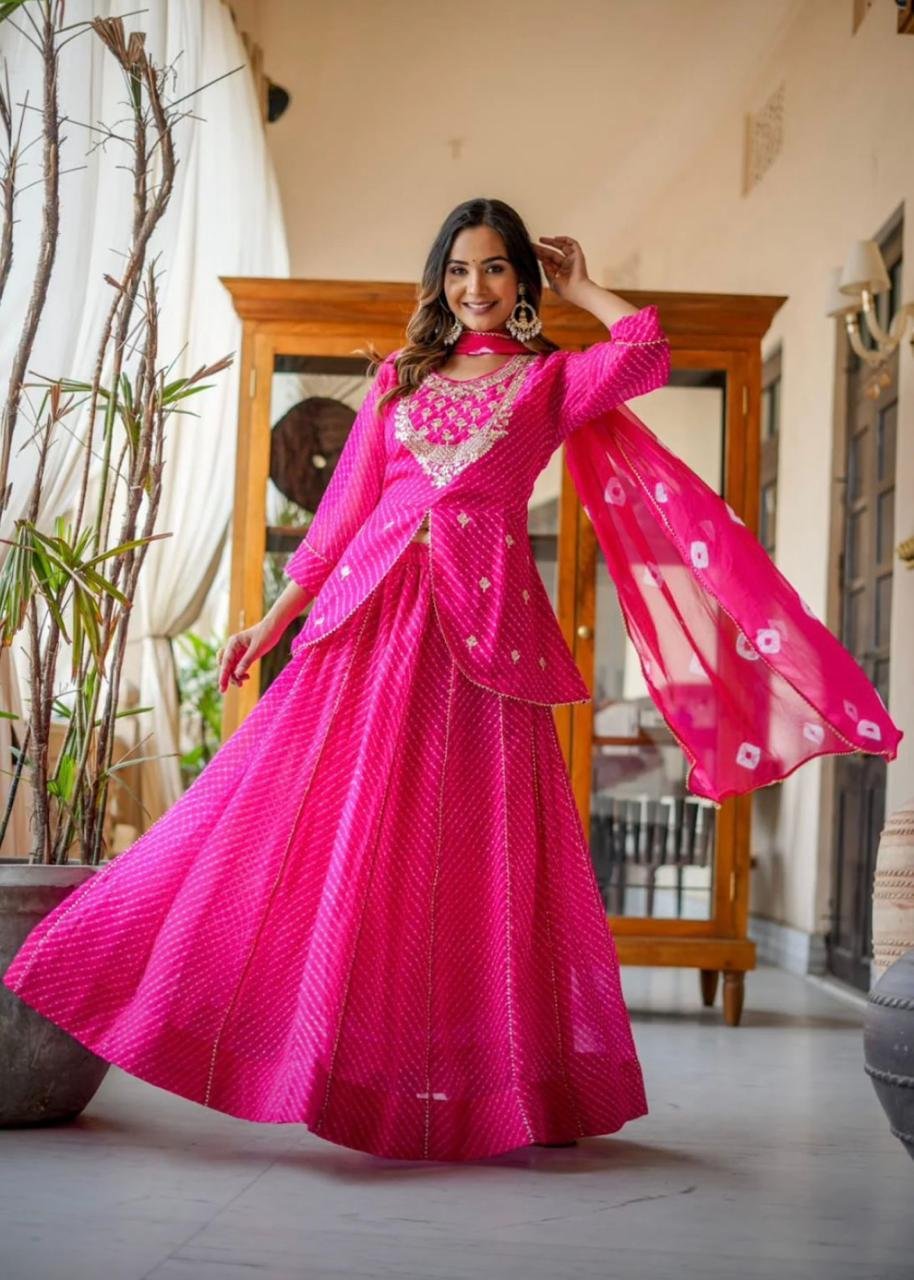 Leheriya Lehenga with Gota Patti and Zardosi Work 3 A woman wearing a vibrant pink Leheriya printed lehenga set with heavy embroidery and a matching bandhej dupatta.