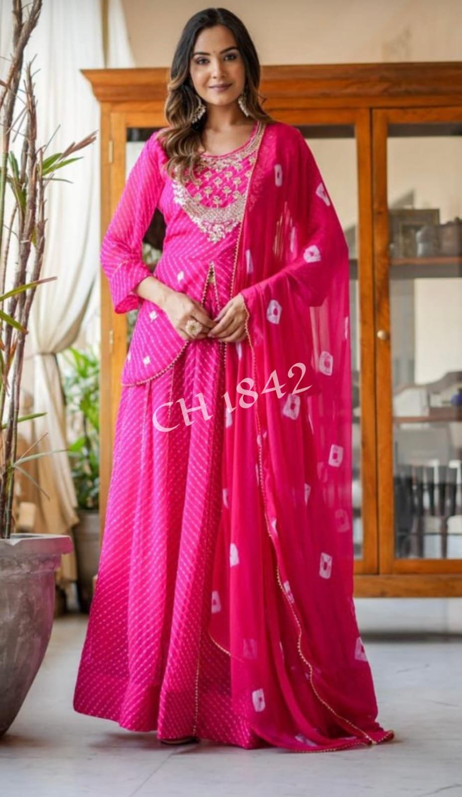 Leheriya Lehenga with Gota Patti and Zardosi Work 5 A woman wearing a vibrant pink Leheriya printed lehenga set with heavy embroidery and a matching bandhej dupatta.