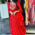 A woman wearing a vibrant pink Leheriya printed lehenga set with heavy embroidery and a matching bandhej dupatta.