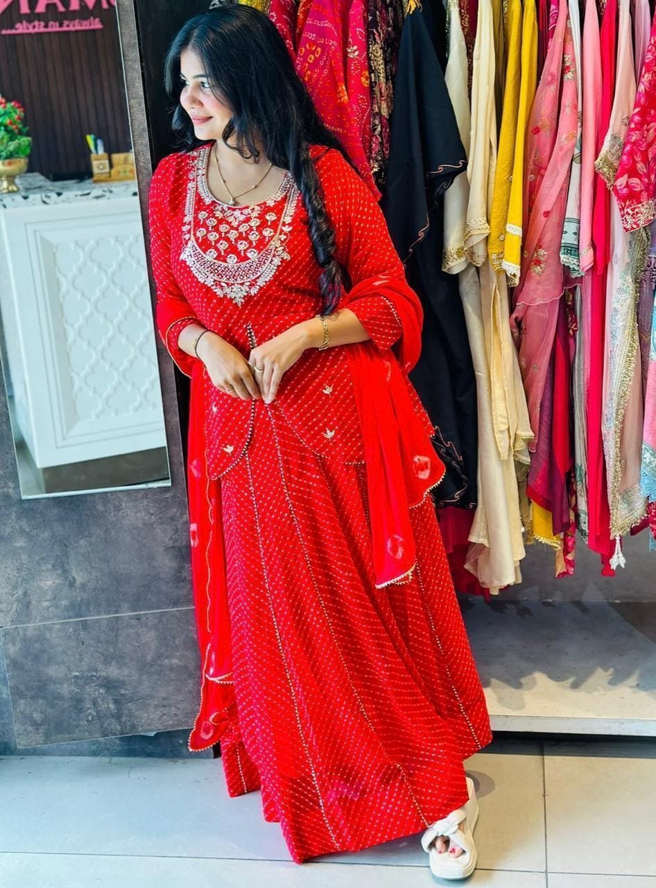 Leheriya Lehenga with Gota Patti and Zardosi Work 6 A woman wearing a vibrant pink Leheriya printed lehenga set with heavy embroidery and a matching bandhej dupatta.