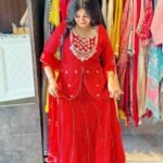 A woman wearing a vibrant pink Leheriya printed lehenga set with heavy embroidery and a matching bandhej dupatta.