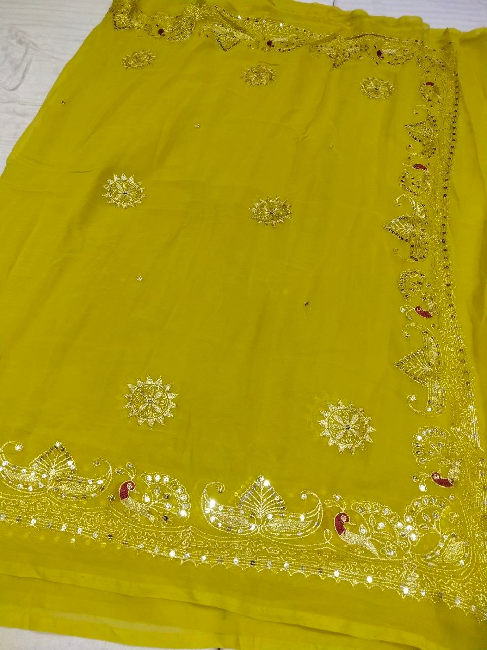Mirror Work Saree in Pure Georgette with Aari Machine Work 1 A bright yellow pure 30g Georgette saree with aari machine work and mirror embellishments along the border and fabric.