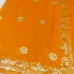 A bright yellow pure 30g Georgette saree with aari machine work and mirror embellishments along the border and fabric.