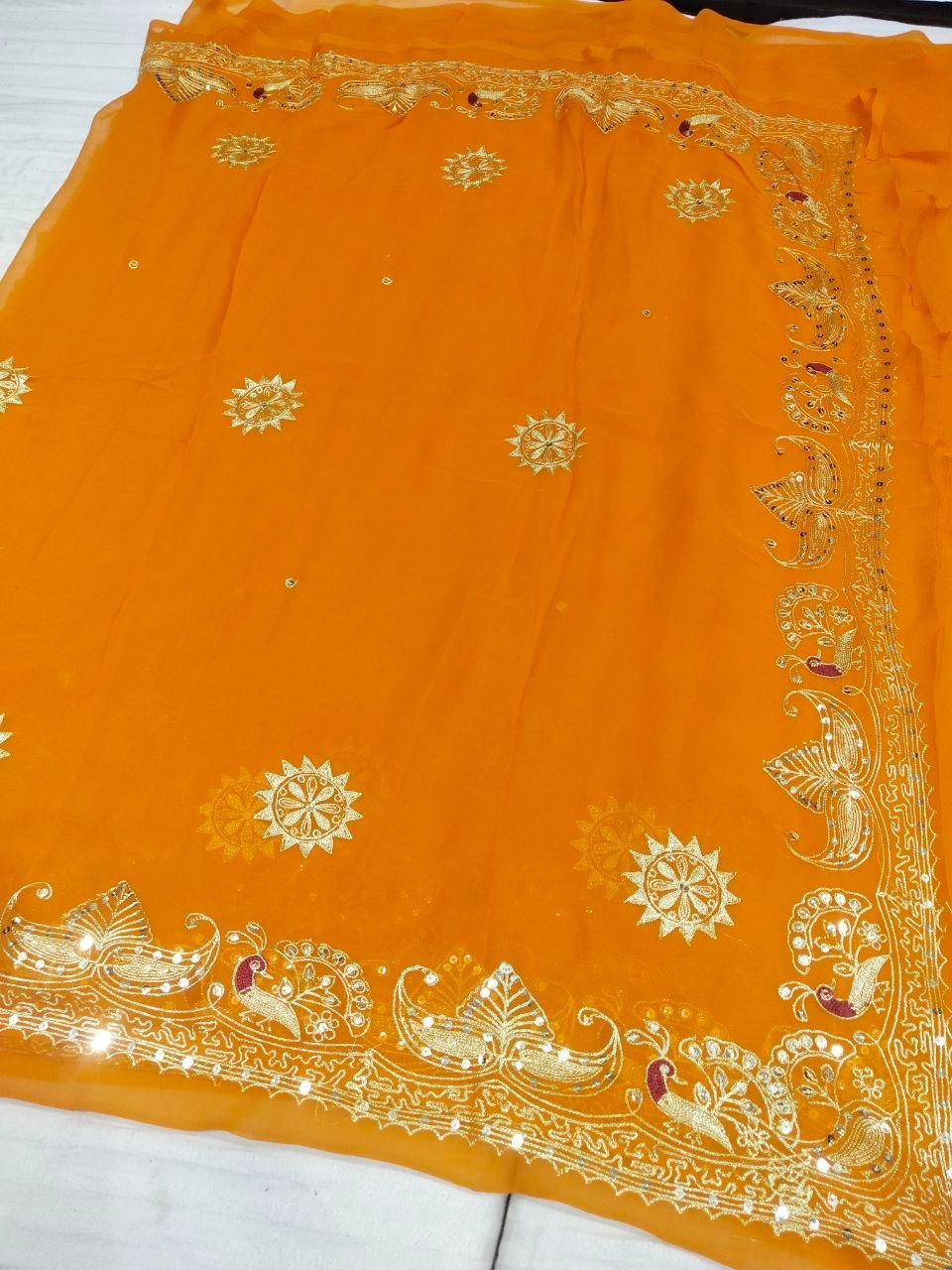 Mirror Work Saree in Pure Georgette with Aari Machine Work 5 A bright yellow pure 30g Georgette saree with aari machine work and mirror embellishments along the border and fabric.