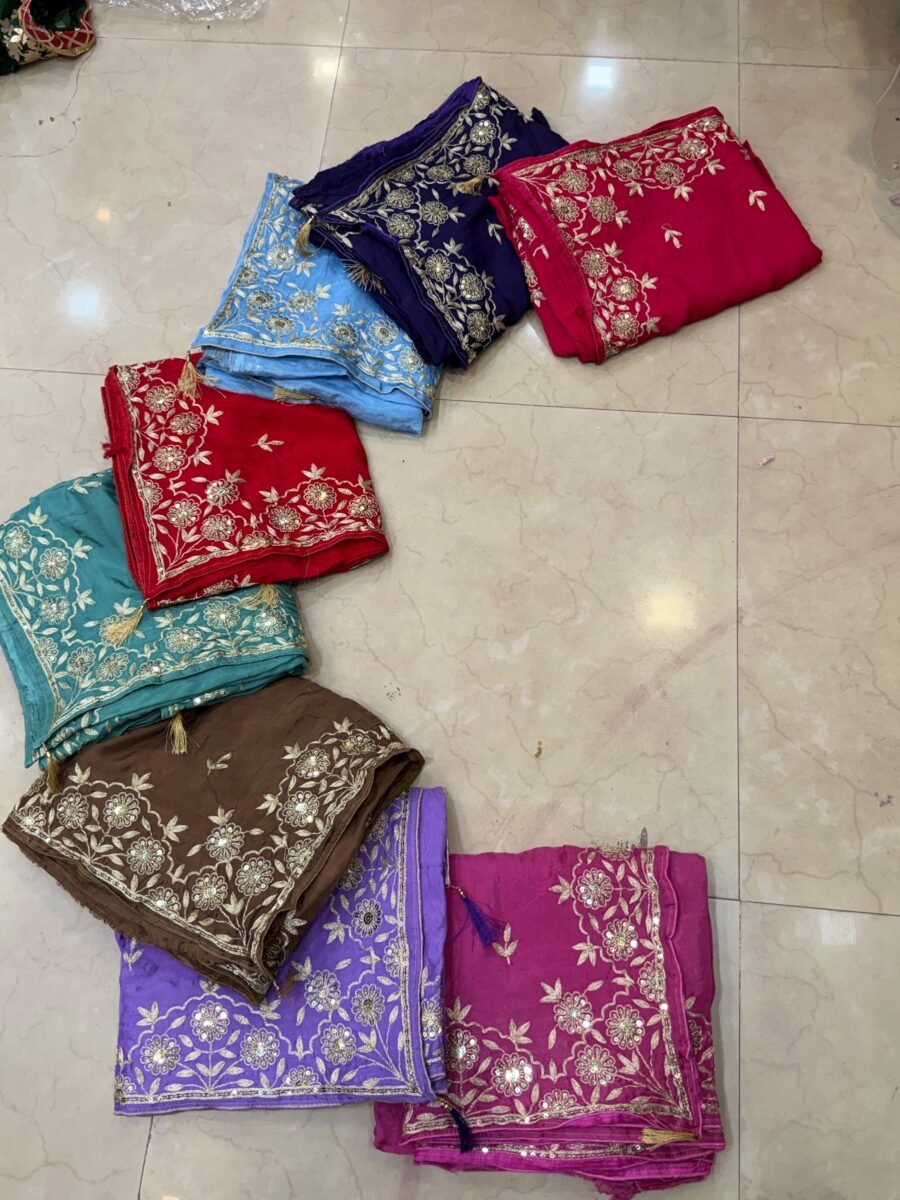 A beautiful collection of Pure Ho silk sarees in various colors, each featuring intricate embroidery work, displayed on a tiled floor.