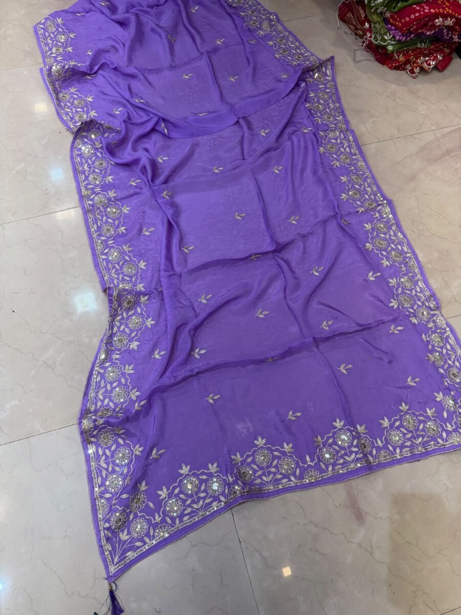 A beautiful purple Pure Ho silk saree adorned with delicate gold handwork embroidery along the borders and on the body.