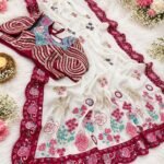 A beautiful white and maroon Rangoli Silk saree displayed with a heavy embroidered stitched blouse on a silver tray.