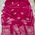 A vibrant red Royal Georgette saree featuring delicate floral handwork embroidery and a detailed border.