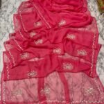 A vibrant red Royal Georgette saree featuring delicate floral handwork embroidery and a detailed border.