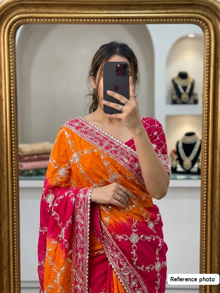 New Arrivals 32 A woman wearing a vibrant orange and pink Russian crepe silk saree with elegant gota lace border and sequence embroidery.