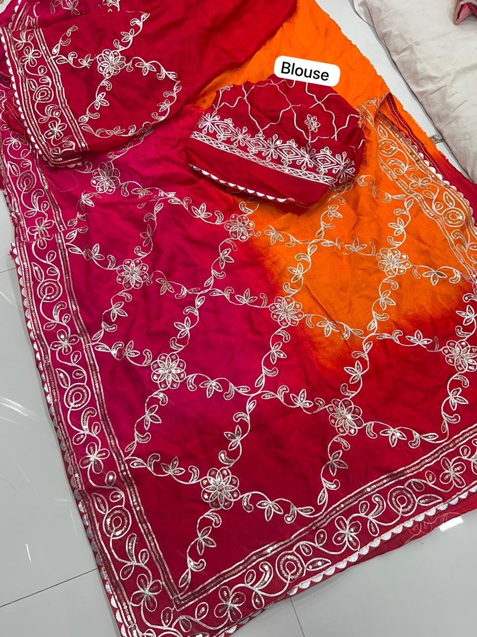 Russian Crepe Silk Saree with Gota Patti and Sequence Work 2 A woman wearing a vibrant orange and pink Russian crepe silk saree with elegant gota lace border and sequence embroidery.