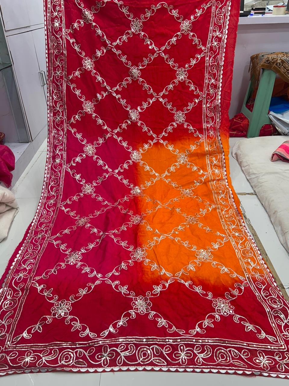 Russian Crepe Silk Saree with Gota Patti and Sequence Work 4 A woman wearing a vibrant orange and pink Russian crepe silk saree with elegant gota lace border and sequence embroidery.