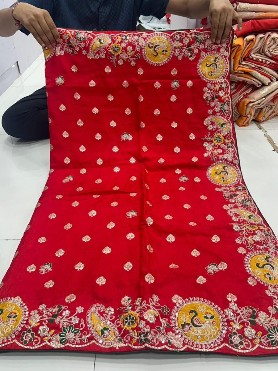 New Arrivals 29 A person holds up a red Upada silk saree featuring a detailed border with multi-sequence work and round peacock motifs.